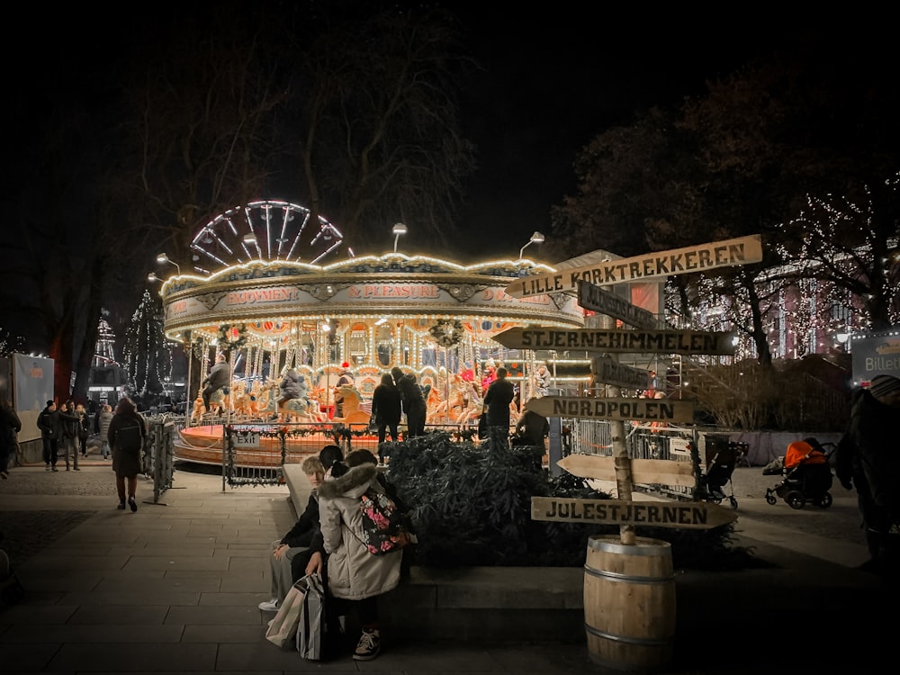 a merry go round at night with people walking around