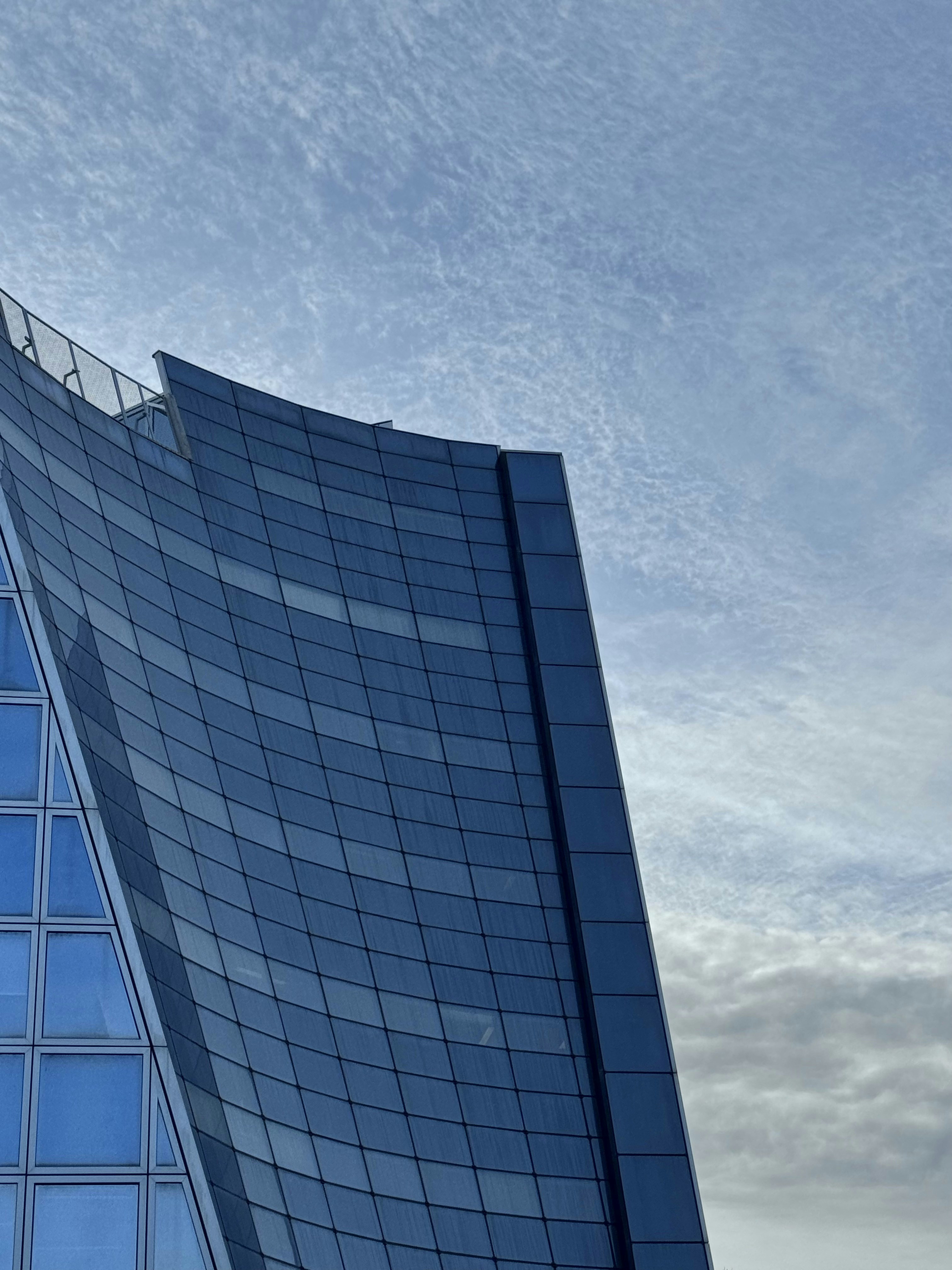 Large modern building over a blue skyby Parsa Farjam