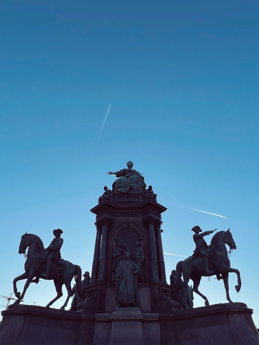 a statue of a man riding a horse next to a clock tower