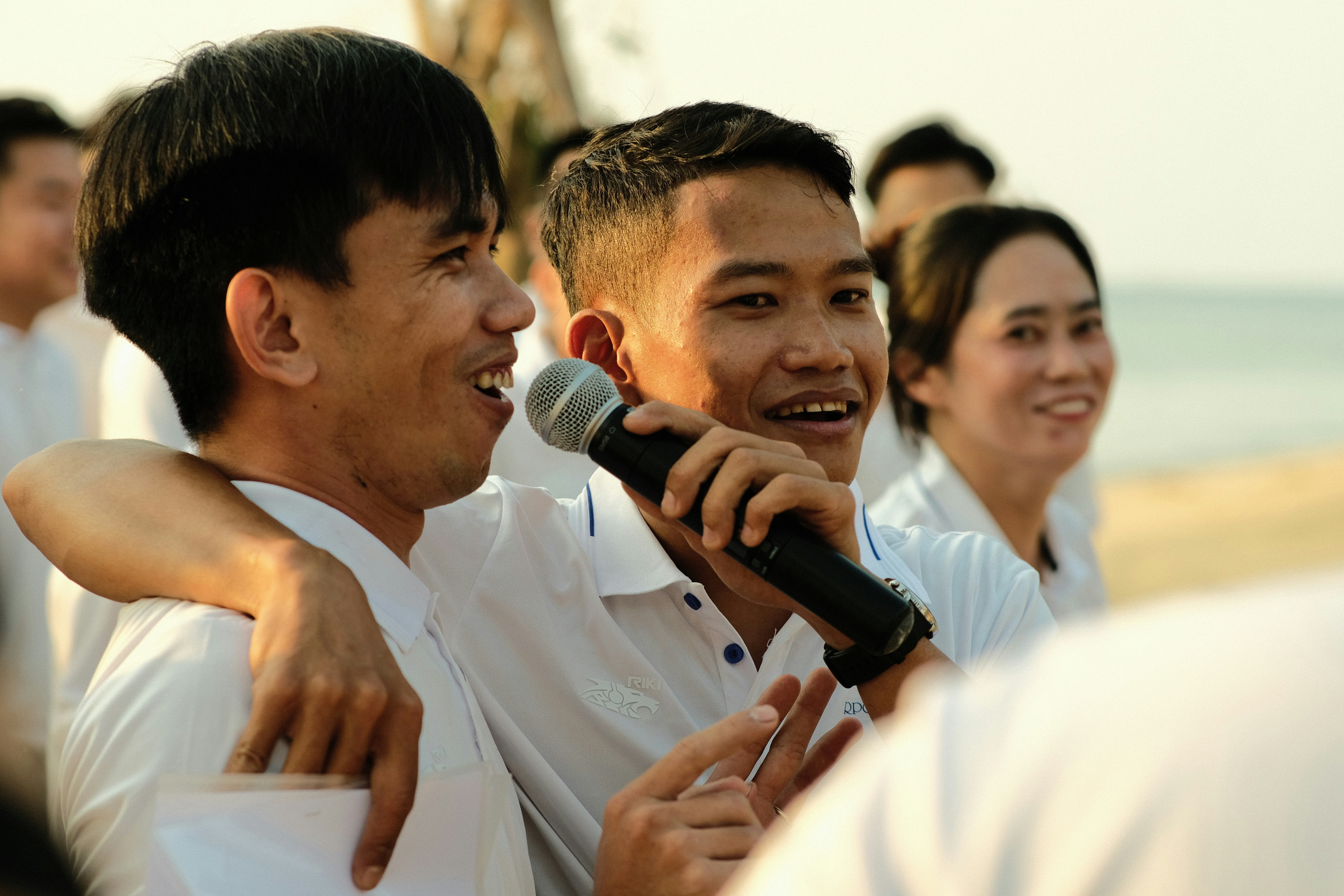 a couple of men standing next to each other holding a microphone