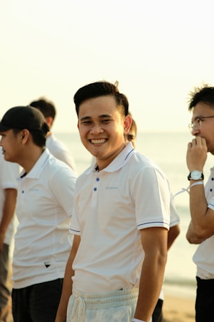 a group of men standing next to each other on a beach