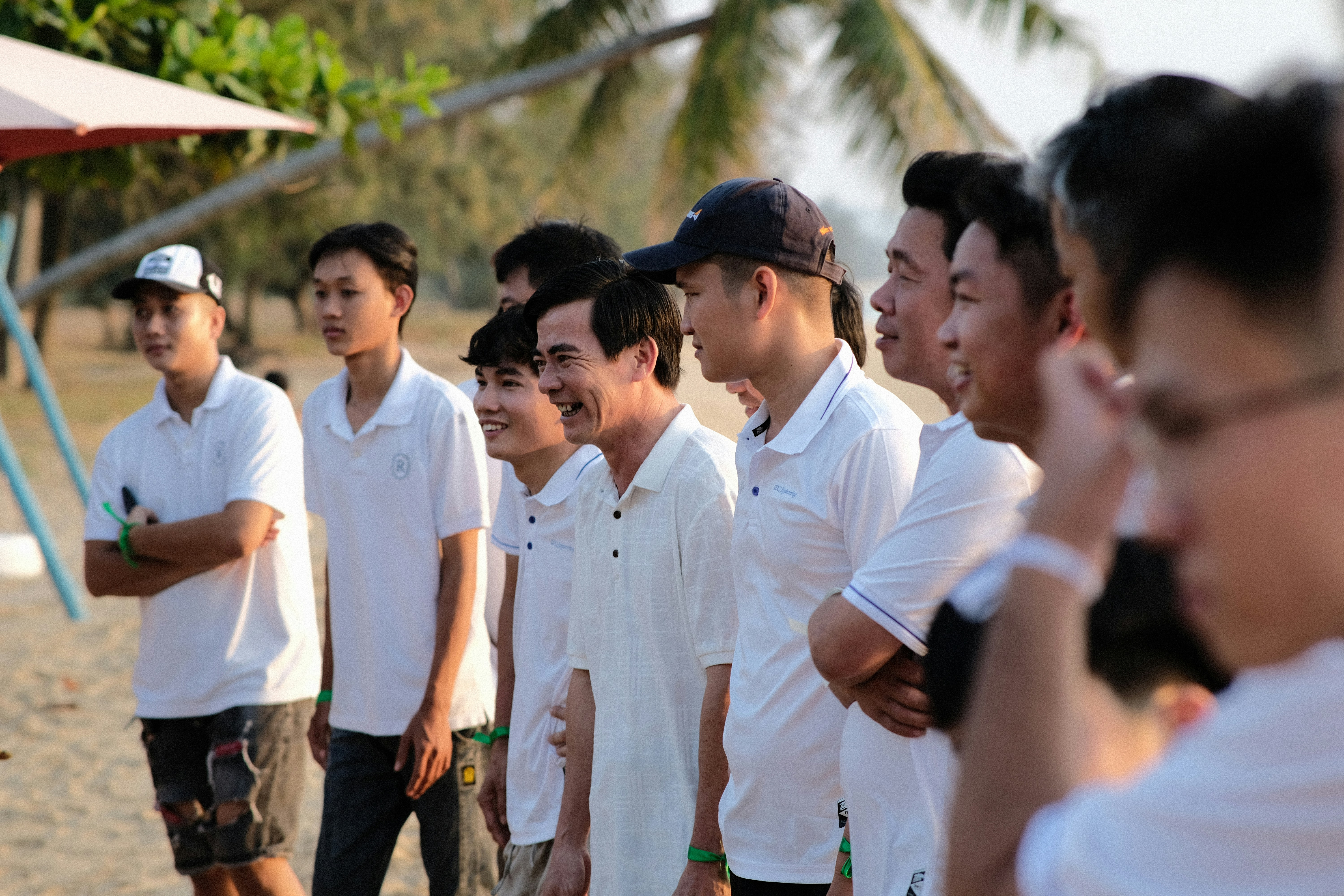 a group of men standing next to each other on a beach