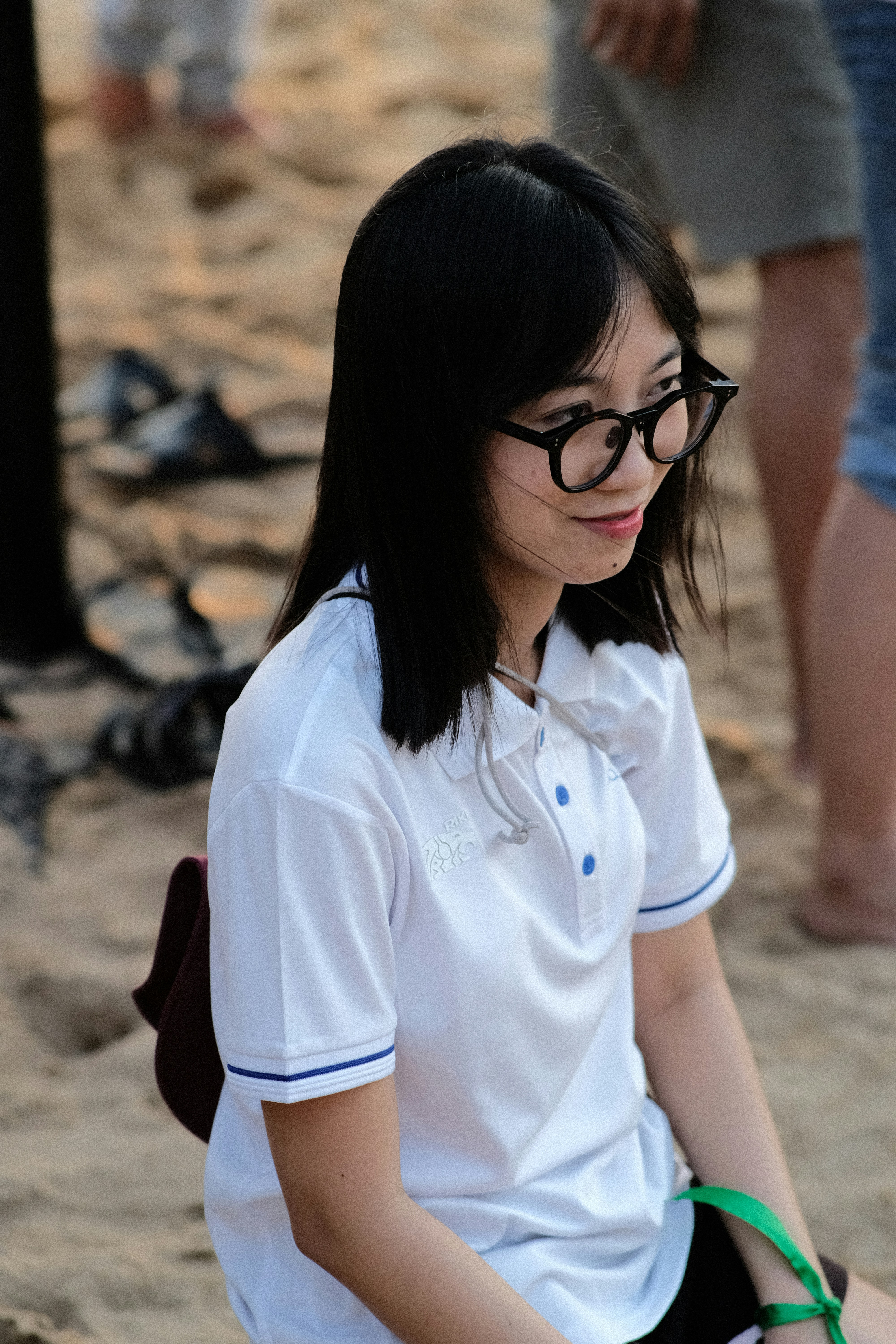 a woman sitting on the ground wearing glasses