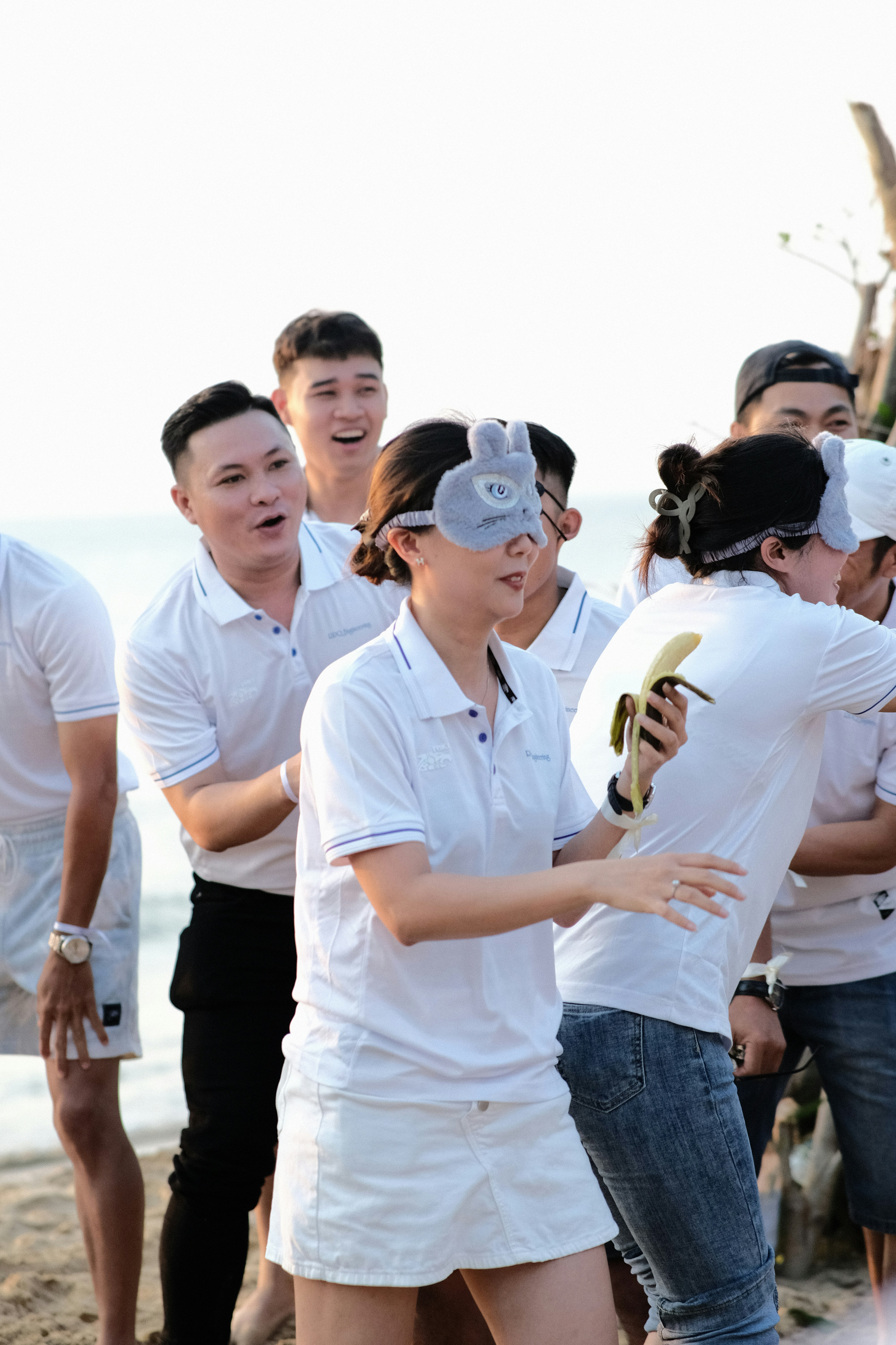 a group of people standing next to each other on a beach