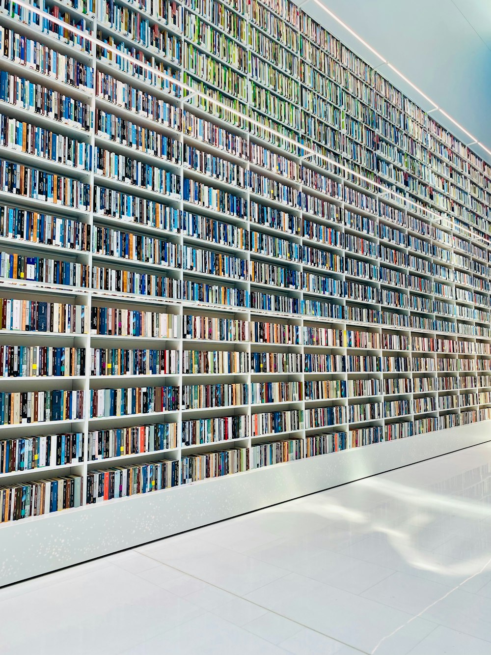 a room filled with lots of books next to a wall