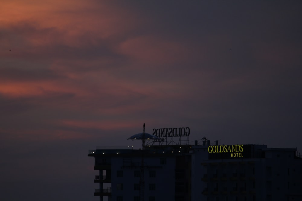 a building with a sign on top of it under a cloudy sky