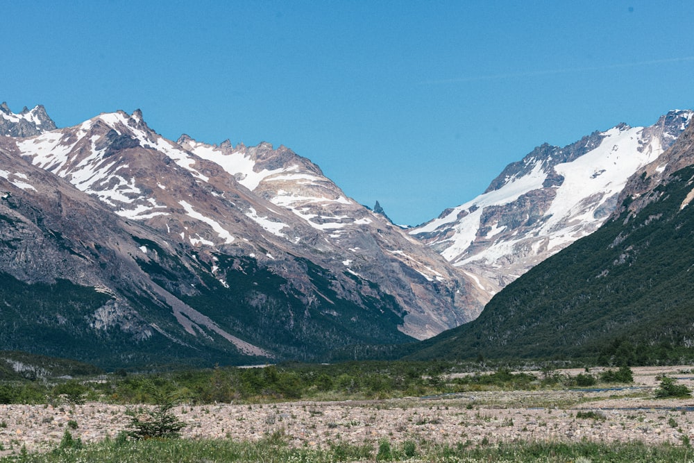 the mountains are covered in snow and grass