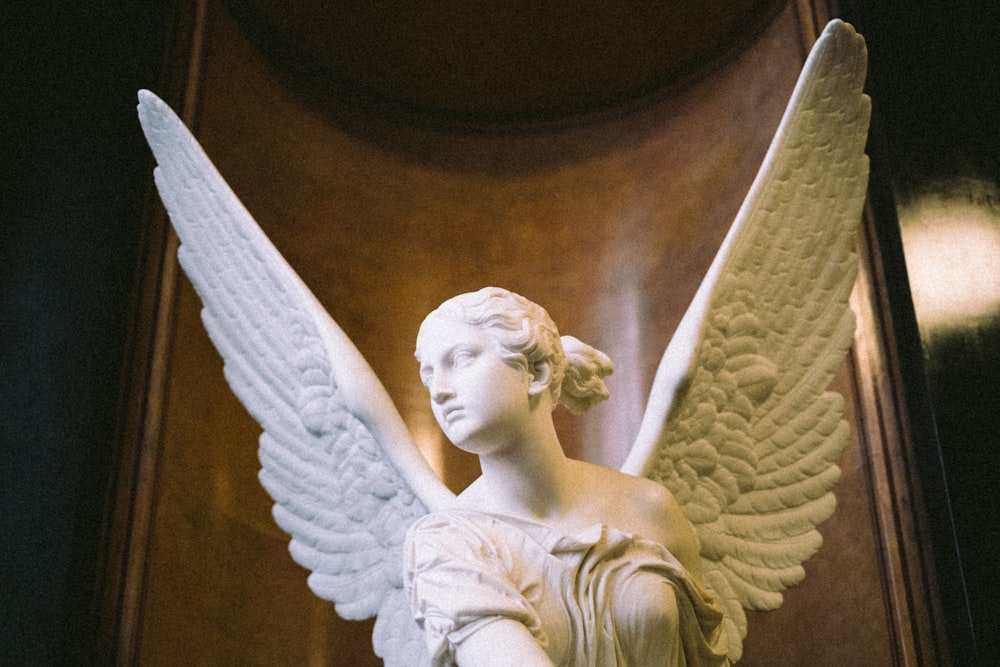 a statue of an angel with white wings