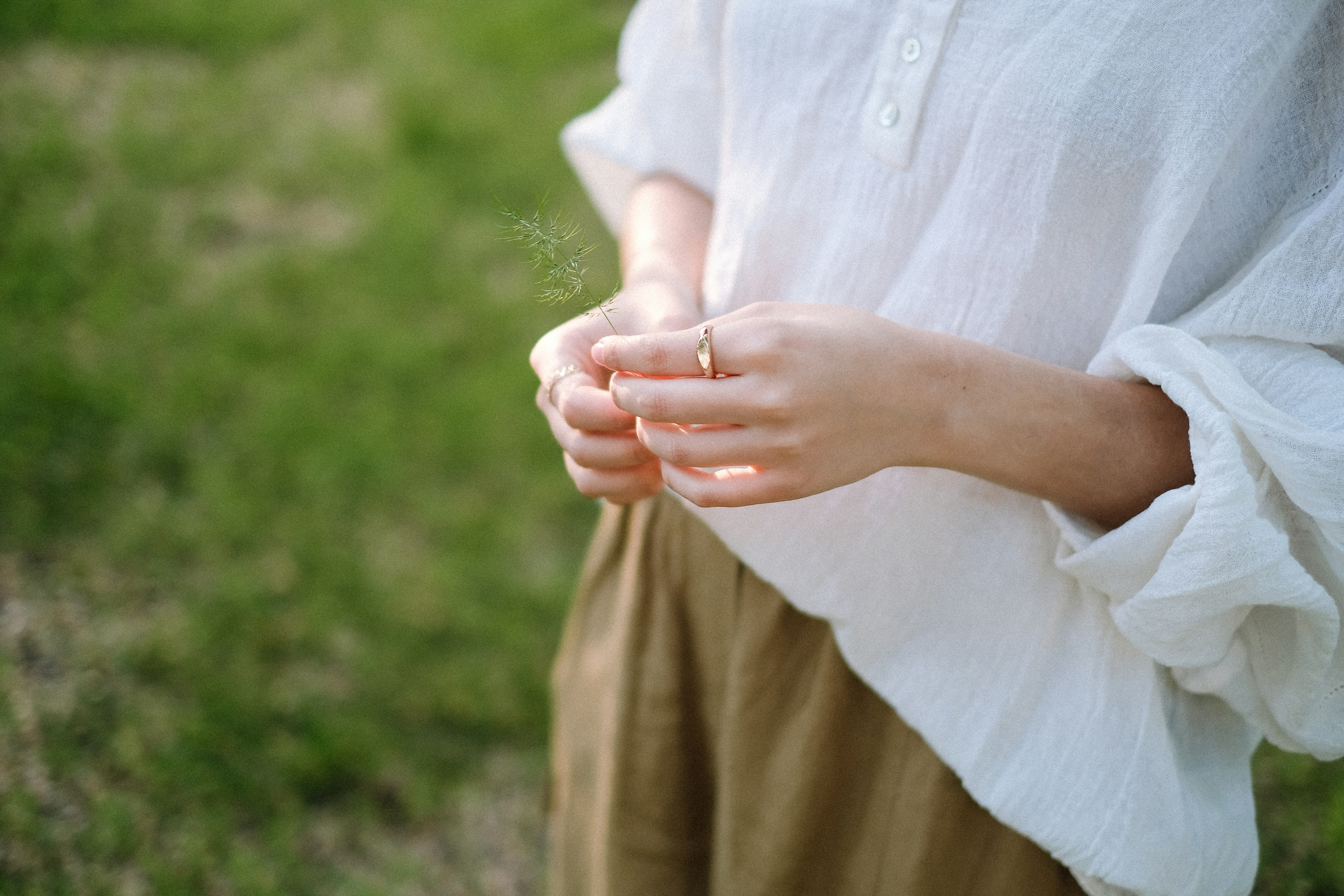 a woman holding a dandelion in her hands