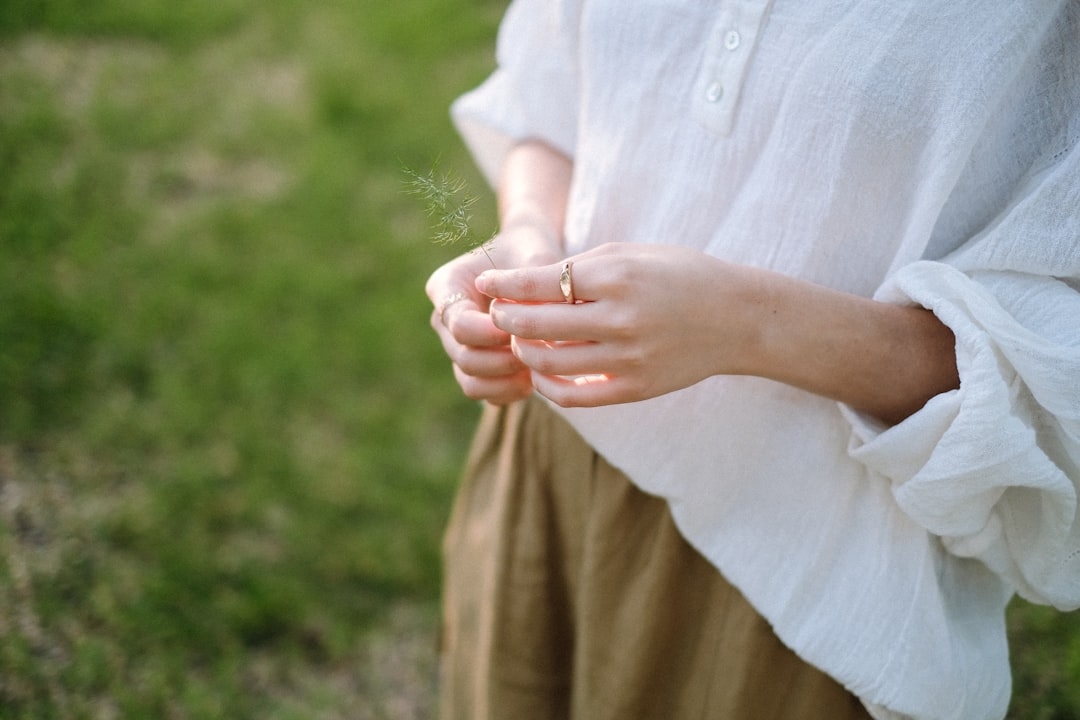 a woman holding a dandelion in her hands