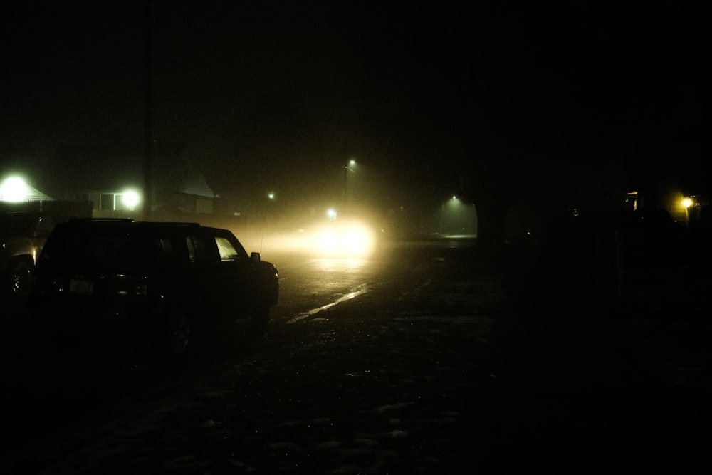 un couple de voitures roulant dans une rue la nuit
