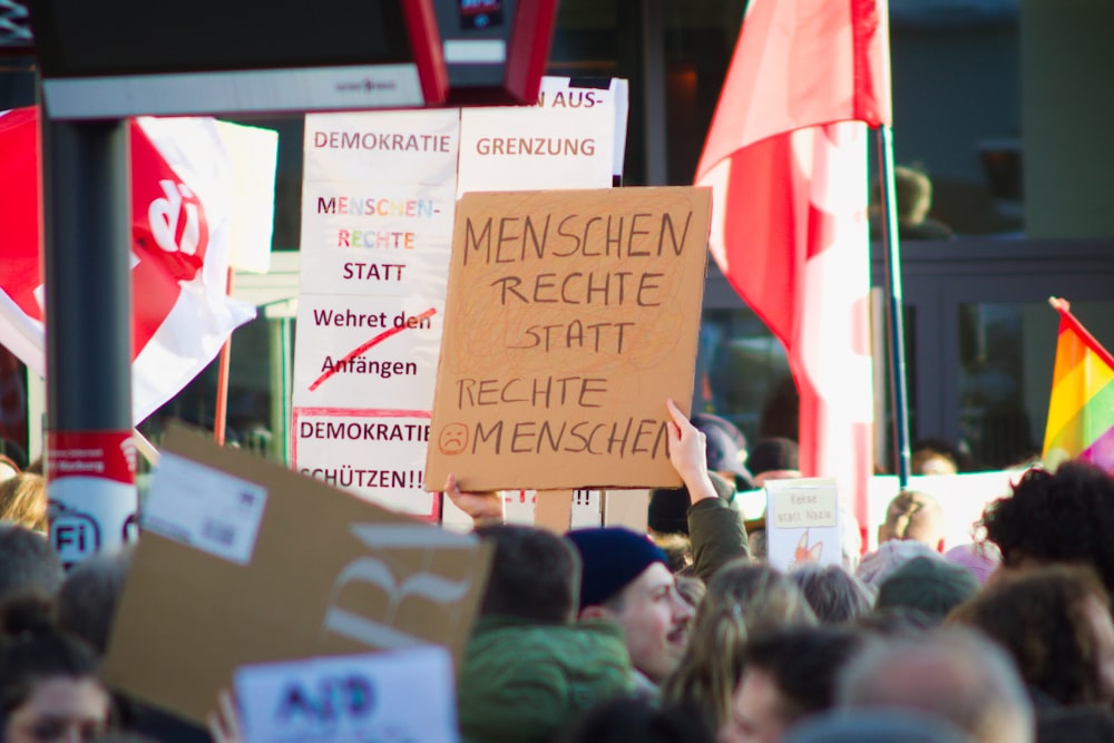 a crowd of people holding signs and flags