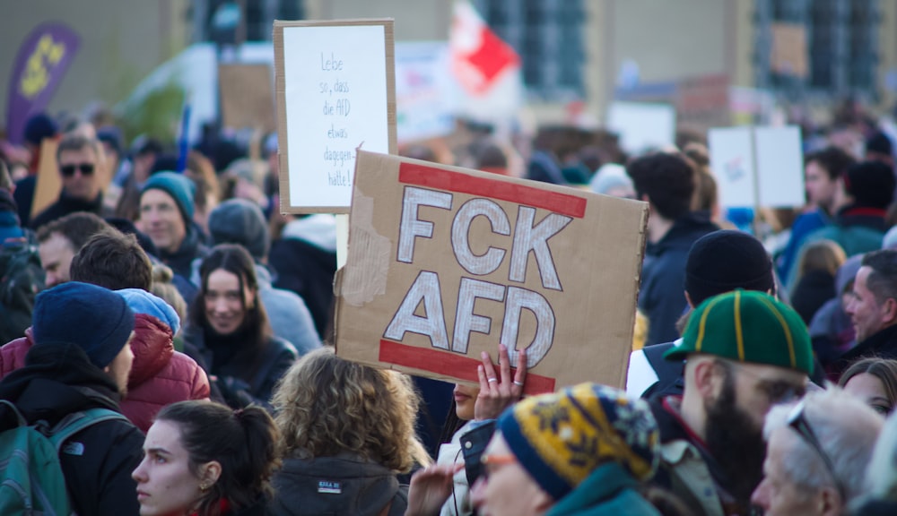 eine Menschenmenge, die Schilder und Plakate hochhält