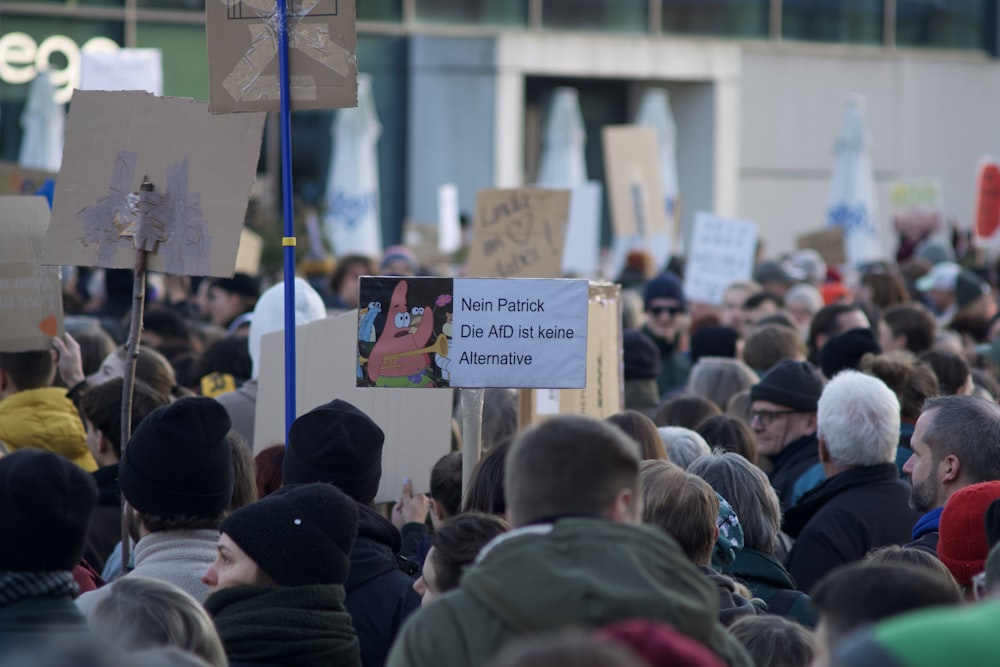 a large crowd of people holding signs and placards