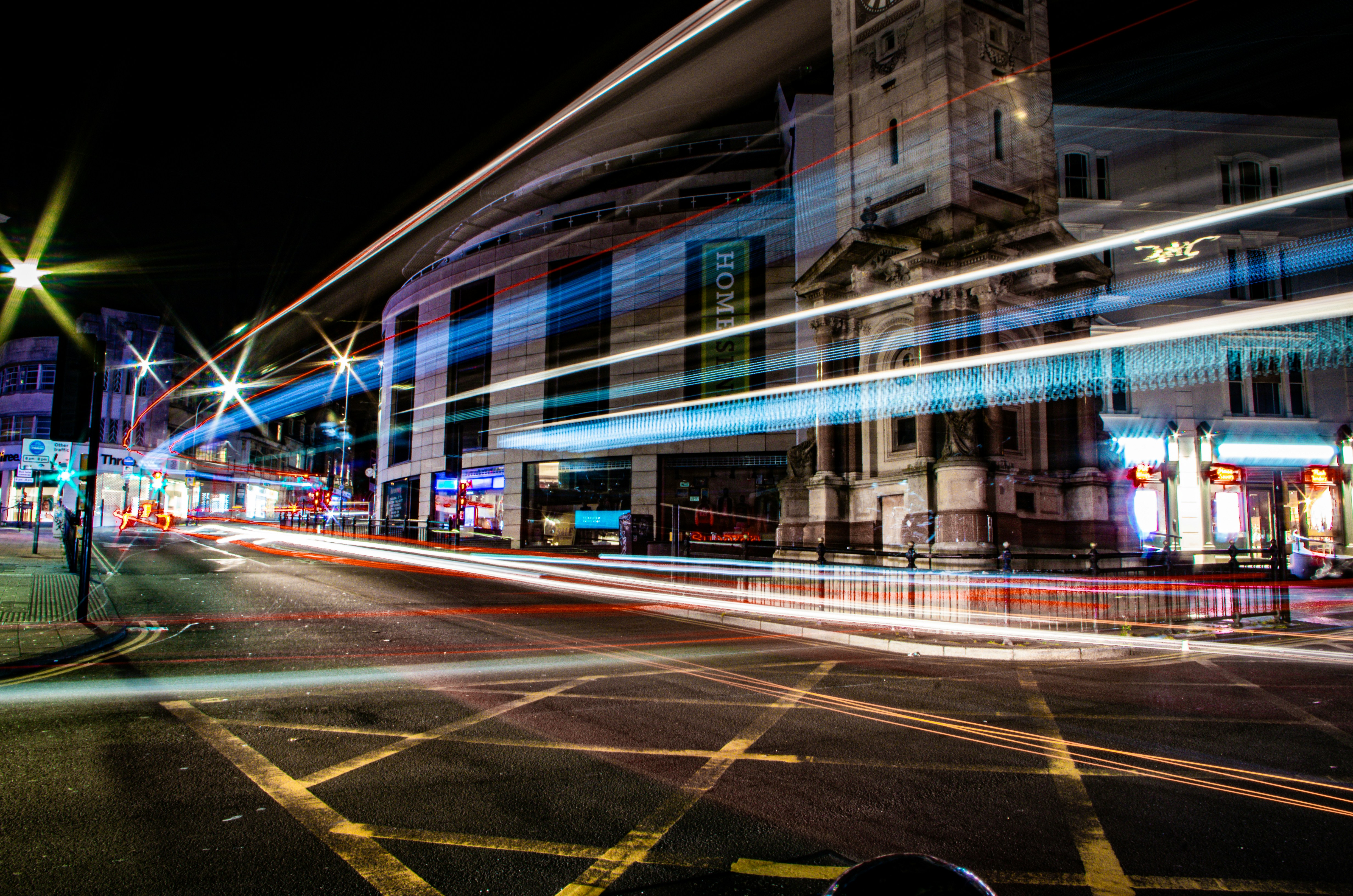 a blurry photo of a city street at night, Long Exposure bus traffic by Brighton Clock Tower