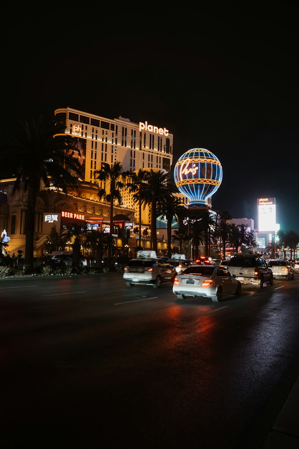 a busy city street at night with cars driving by