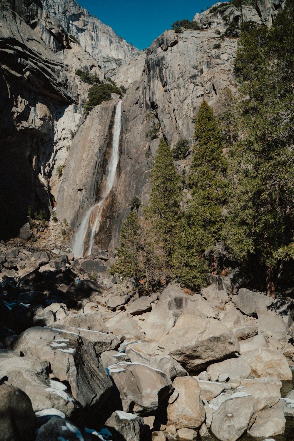 a waterfall in the middle of some rocks and trees