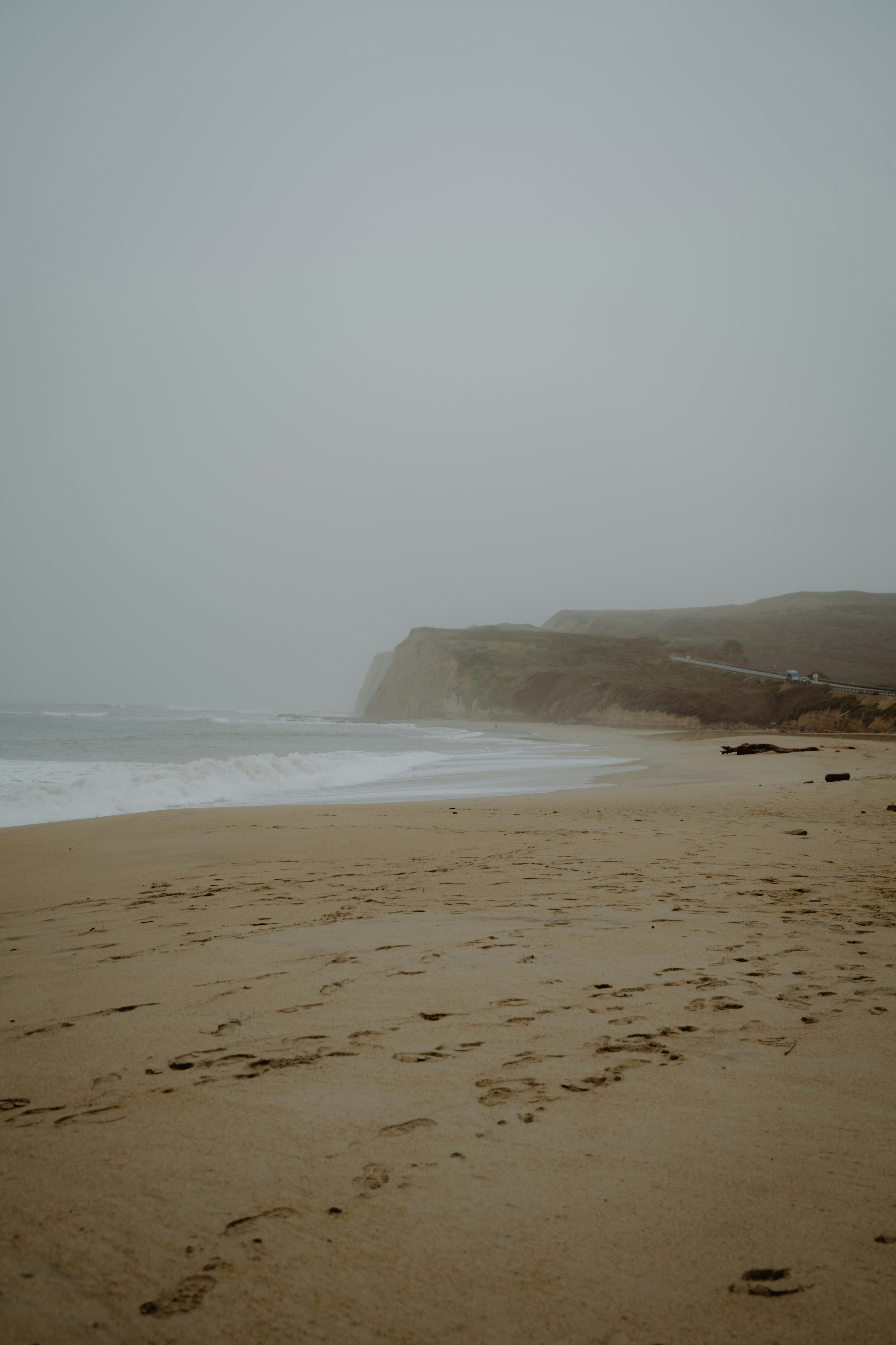a sandy beach with footprints in the sand