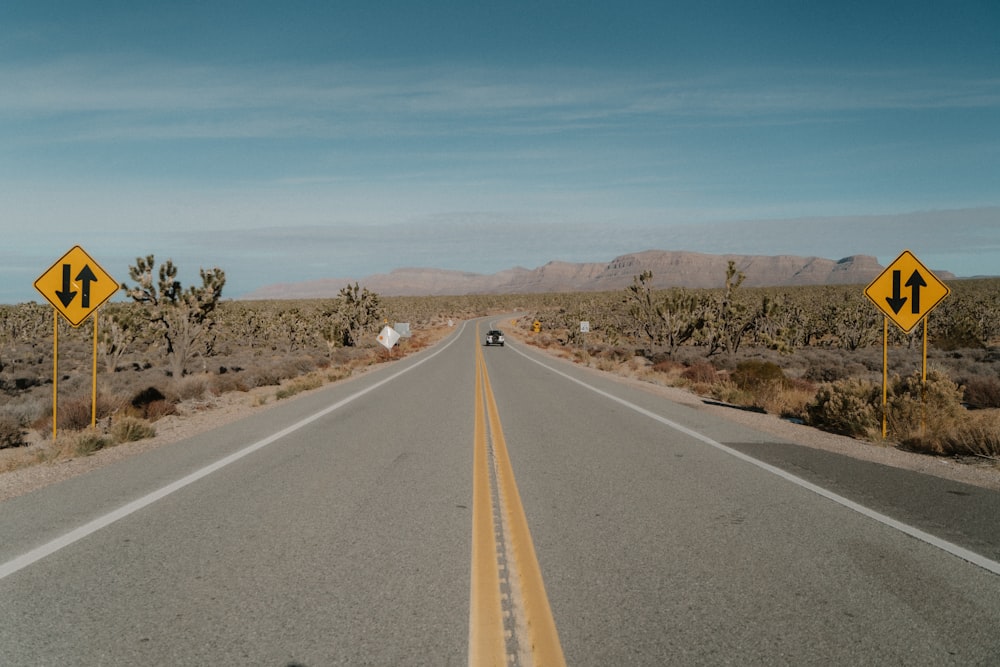 a car driving down an empty road in the desert