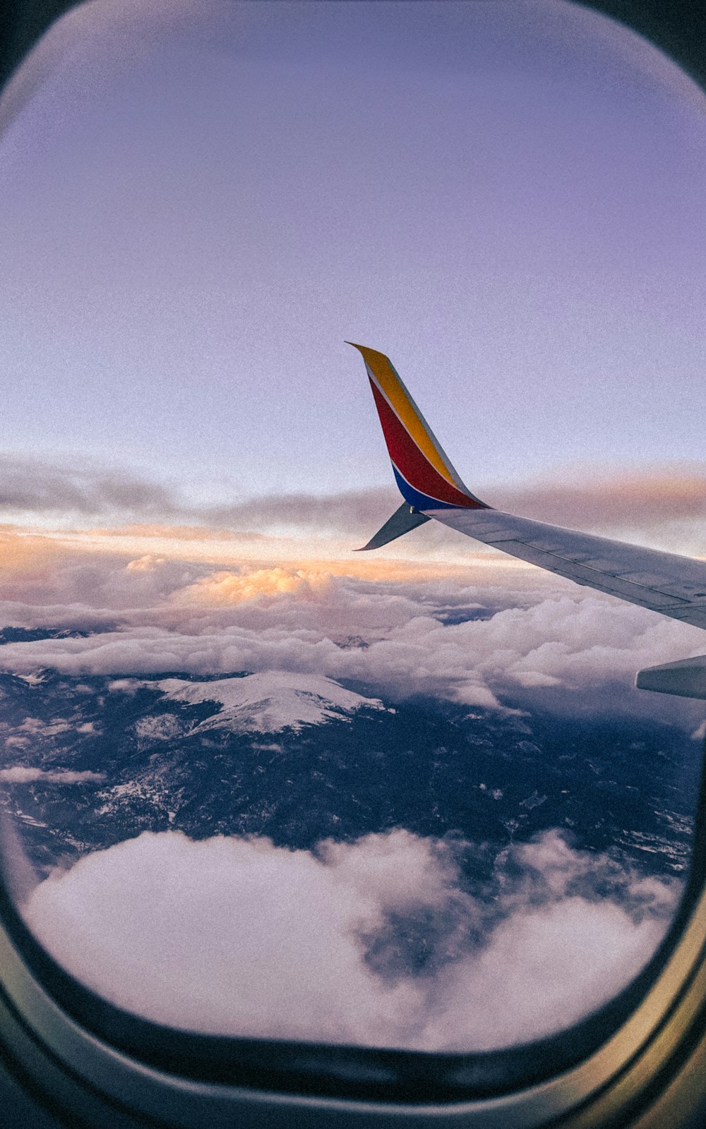 a view of the wing of an airplane over clouds