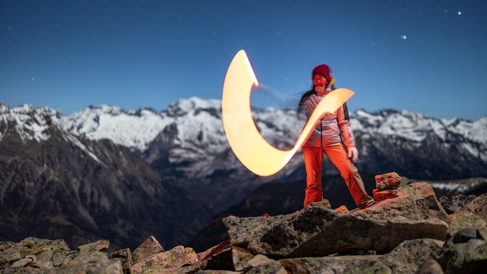 uma mulher no topo de uma montanha segurando um frisbee