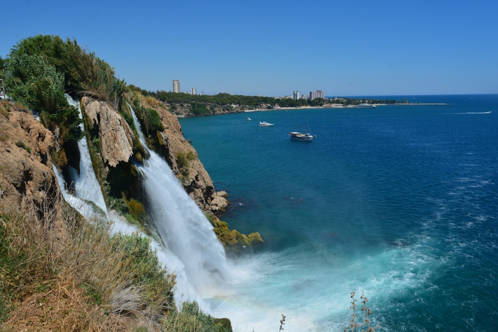 a large waterfall with a boat in the water