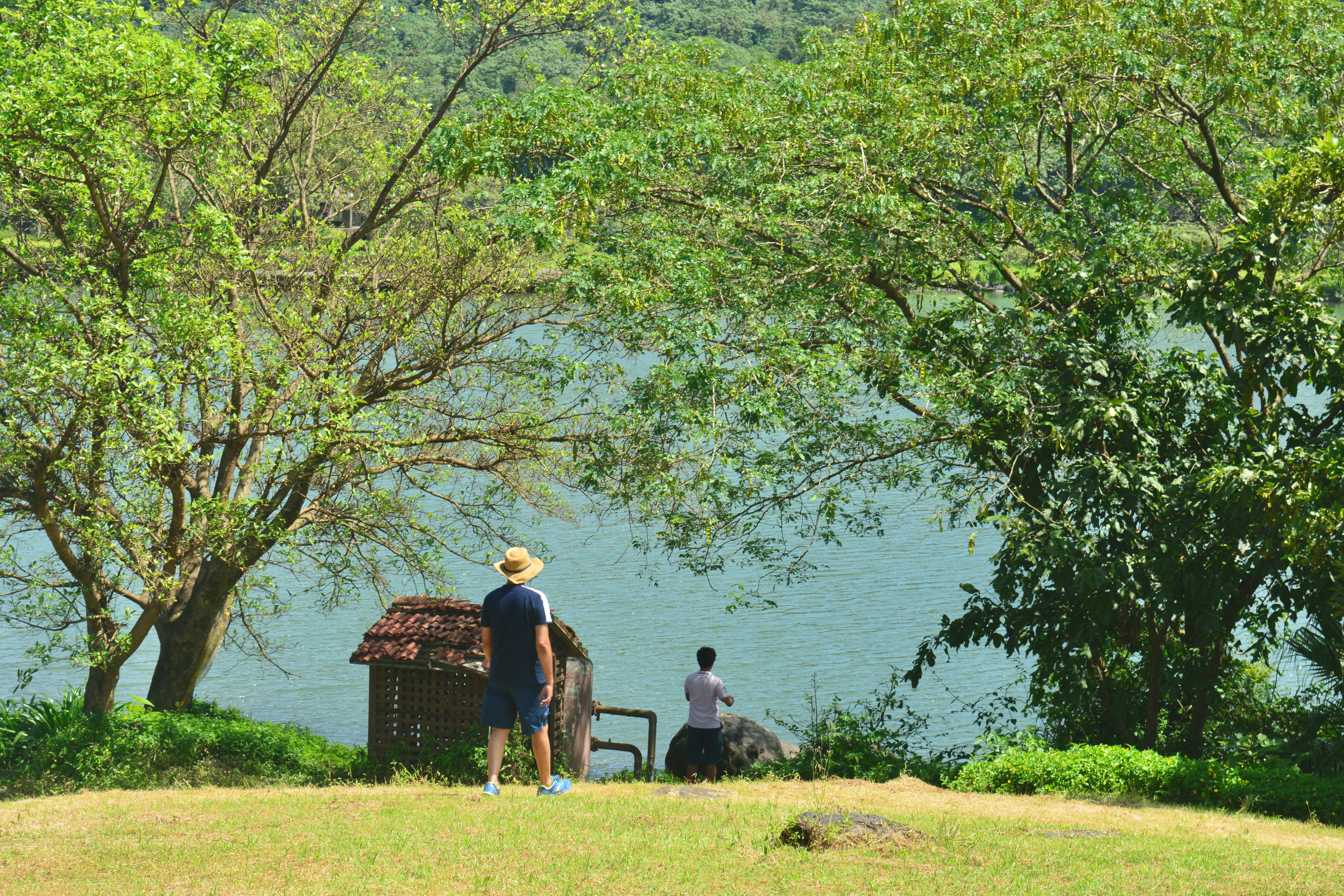 a couple of people standing next to a body of water