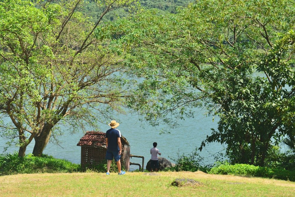 a couple of people standing next to a body of water