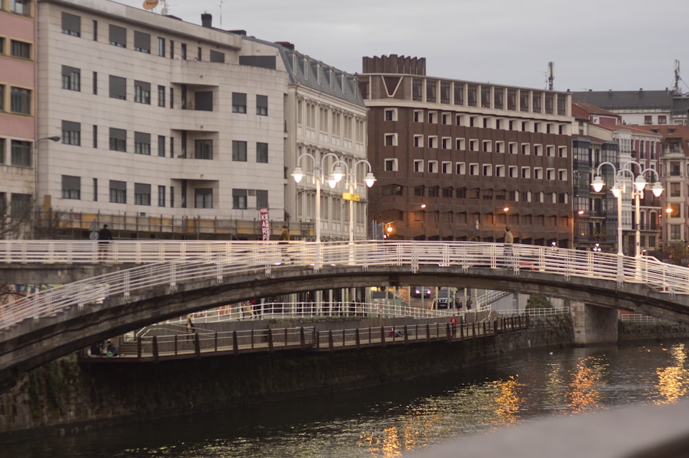 a bridge over a body of water with buildings in the background