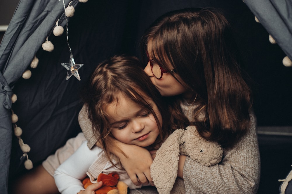 deux petites filles s’étreignant dans une tente