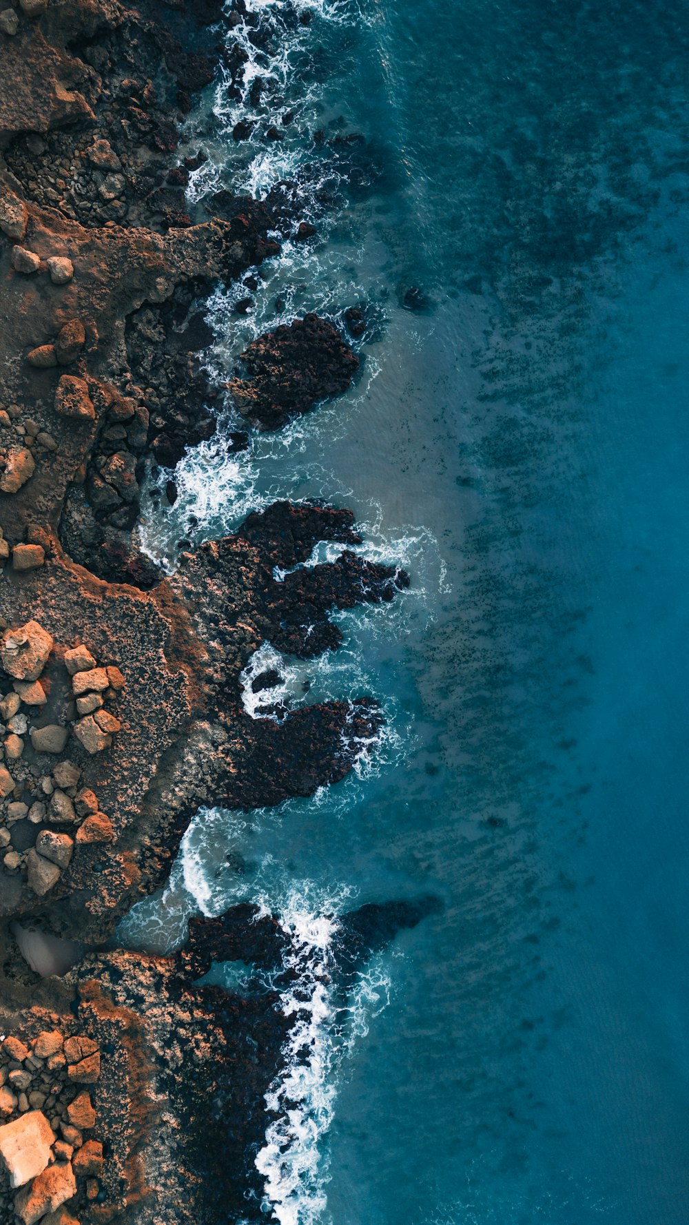 an aerial view of a rocky beach and the ocean