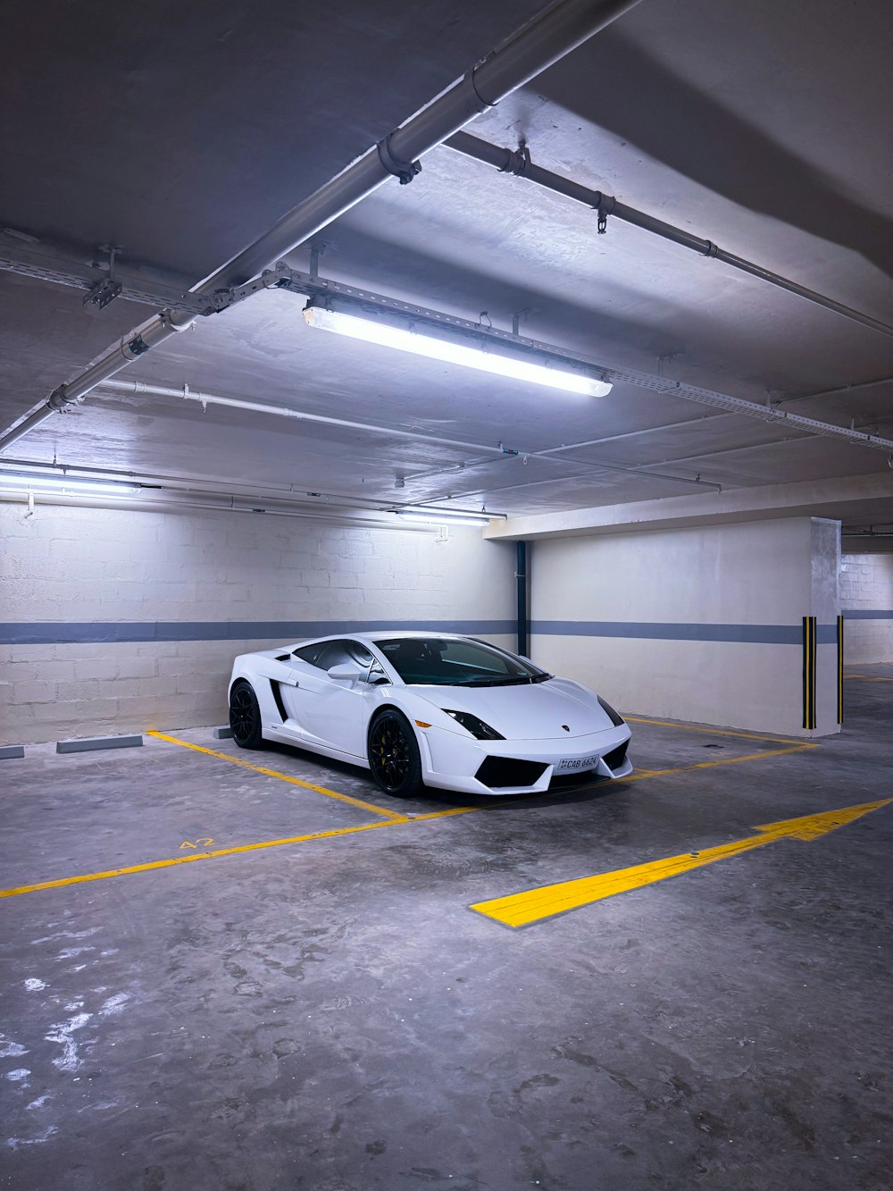 a white sports car parked in a parking garage