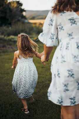 a woman and a little girl holding hands