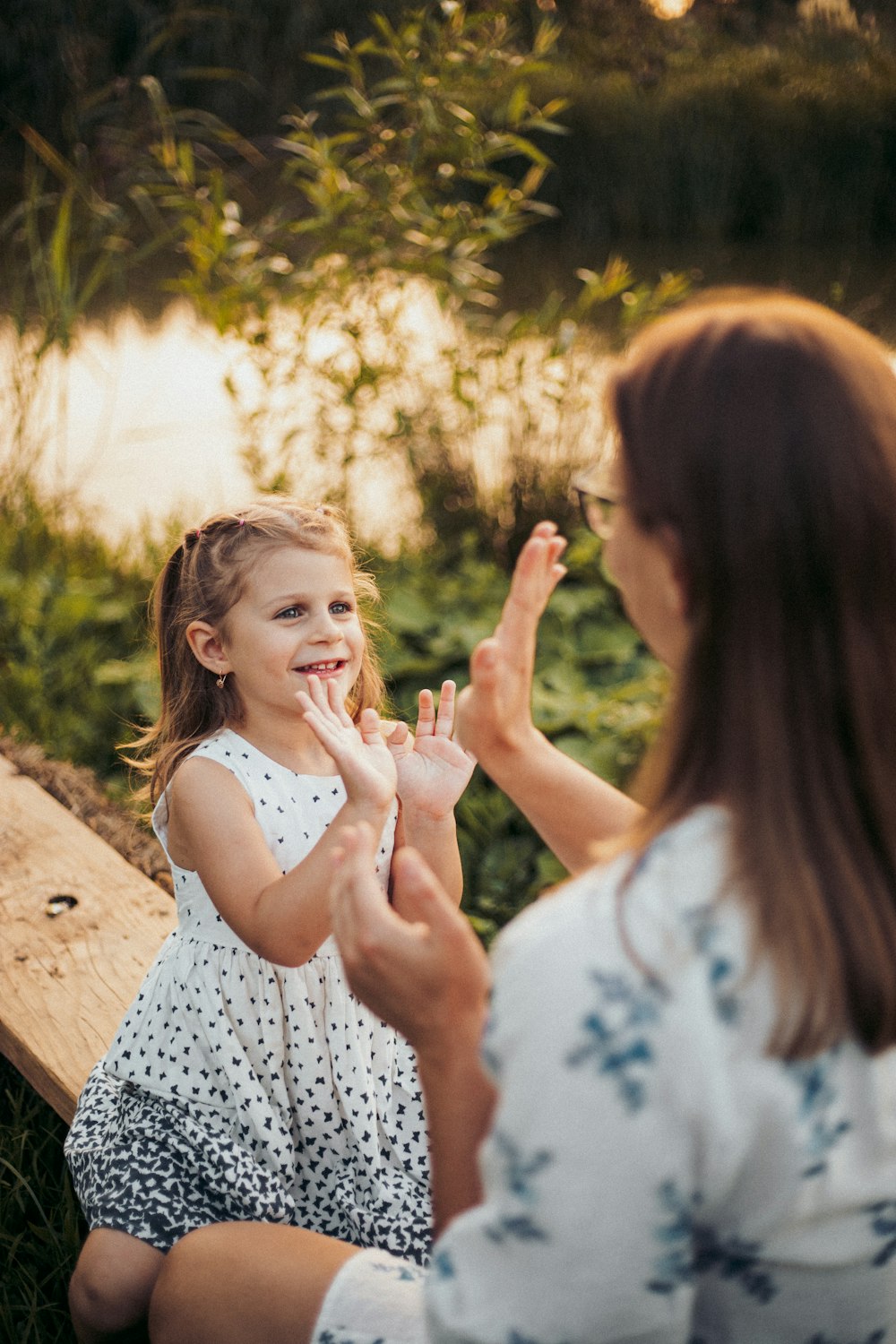 a woman and a little girl sitting on a bench