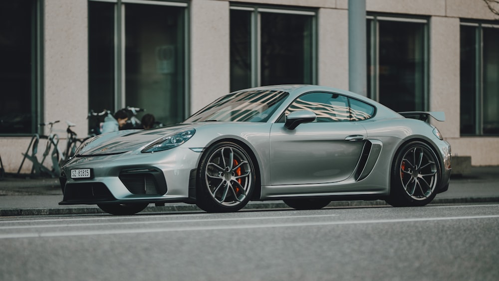 a silver sports car parked on the side of the road