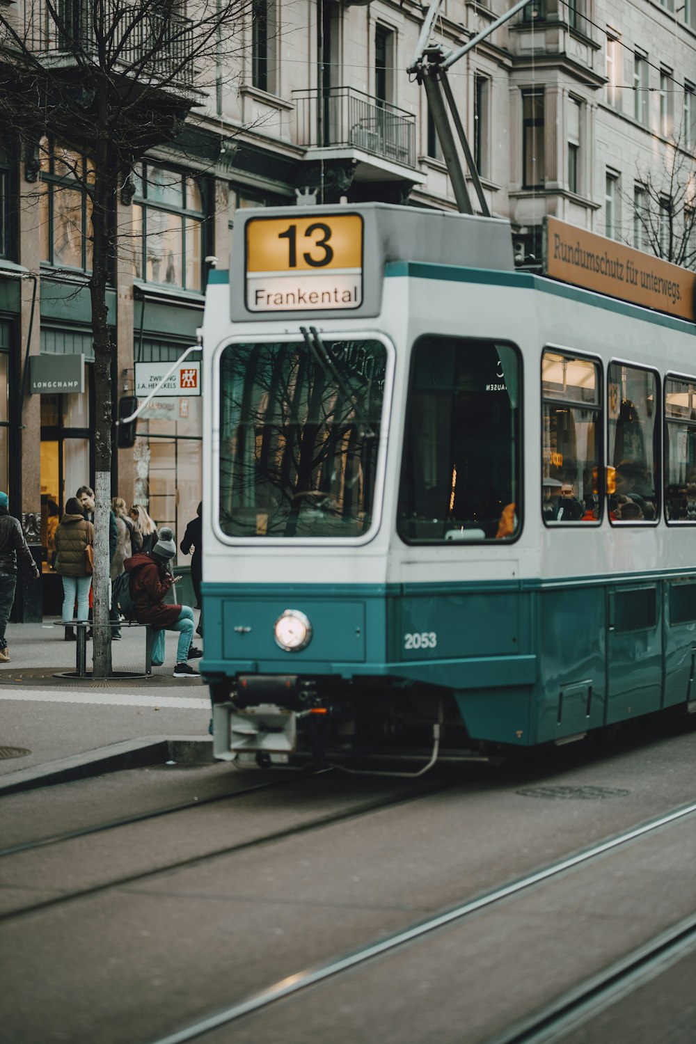 a blue and white trolley on a city street