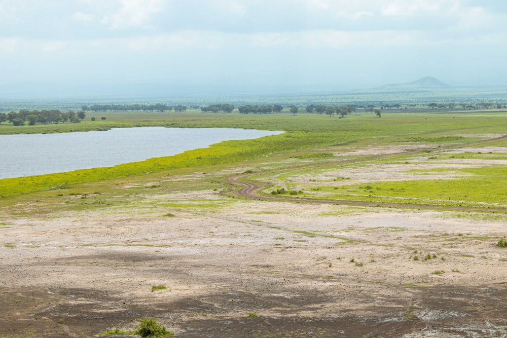 um grande corpo de água sentado ao lado de um campo verde exuberante