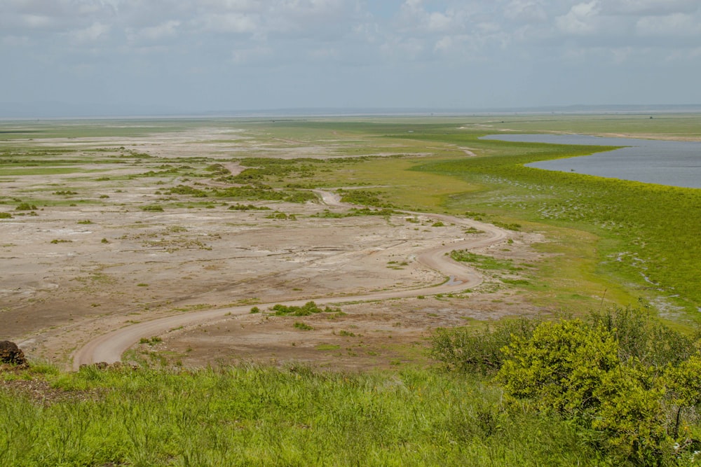 a wide open field with a body of water in the distance