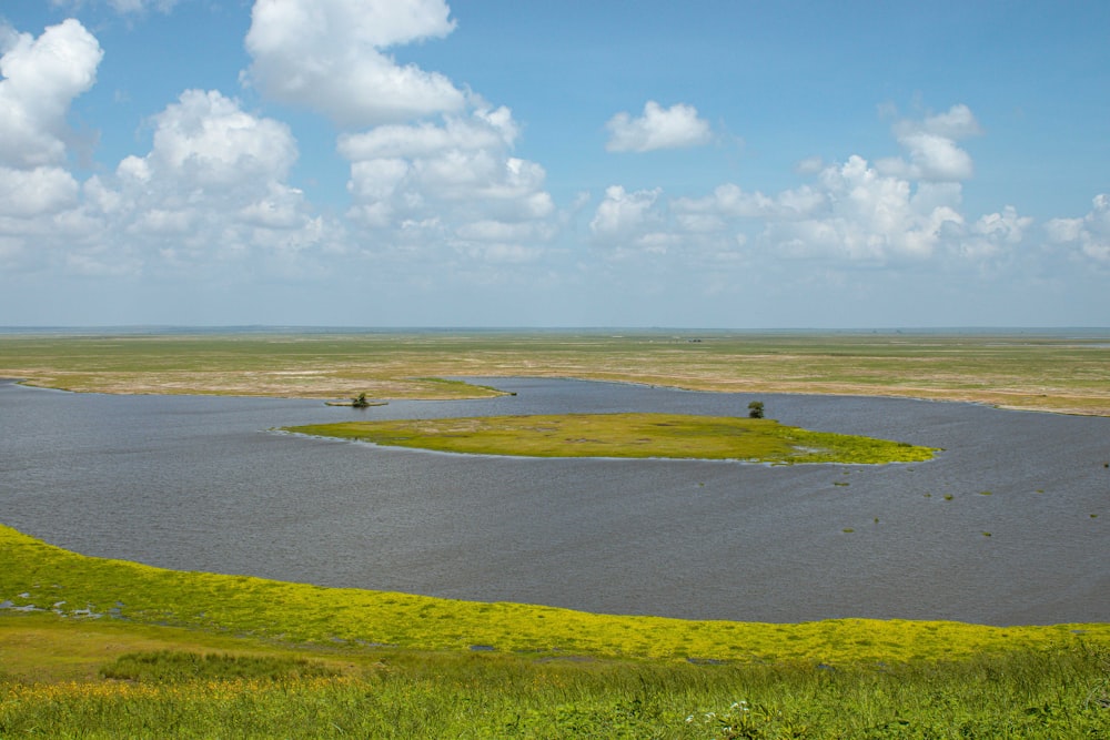 um grande corpo de água cercado por um campo verde exuberante