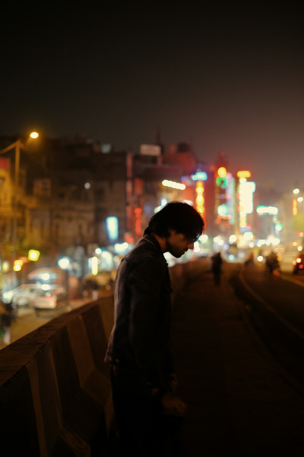 a man standing on a bridge looking at his cell phone