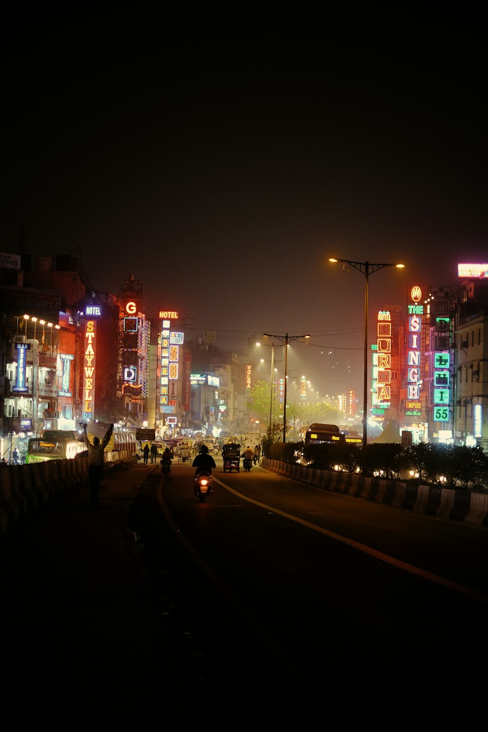 Eine nächtliche Stadtstraße mit hohen Gebäuden, die beleuchtet sind