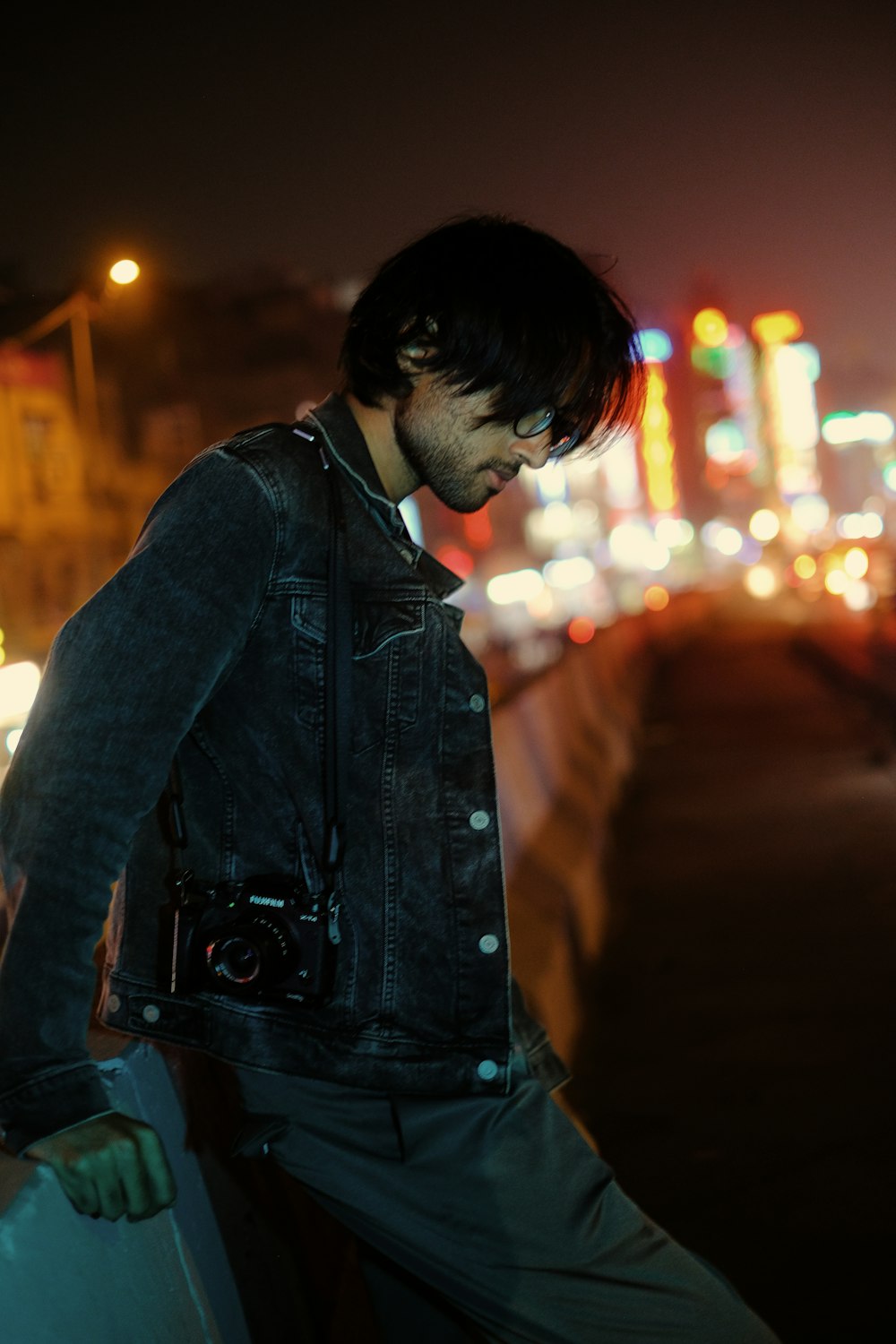 a man standing next to a wall at night