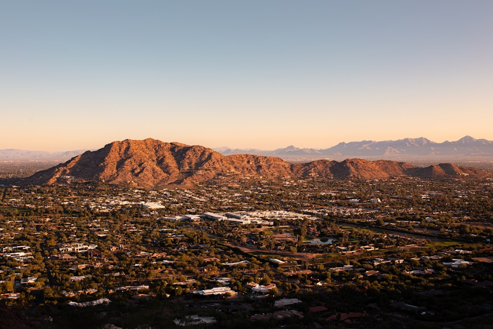 an aerial view of a city with mountains in the background