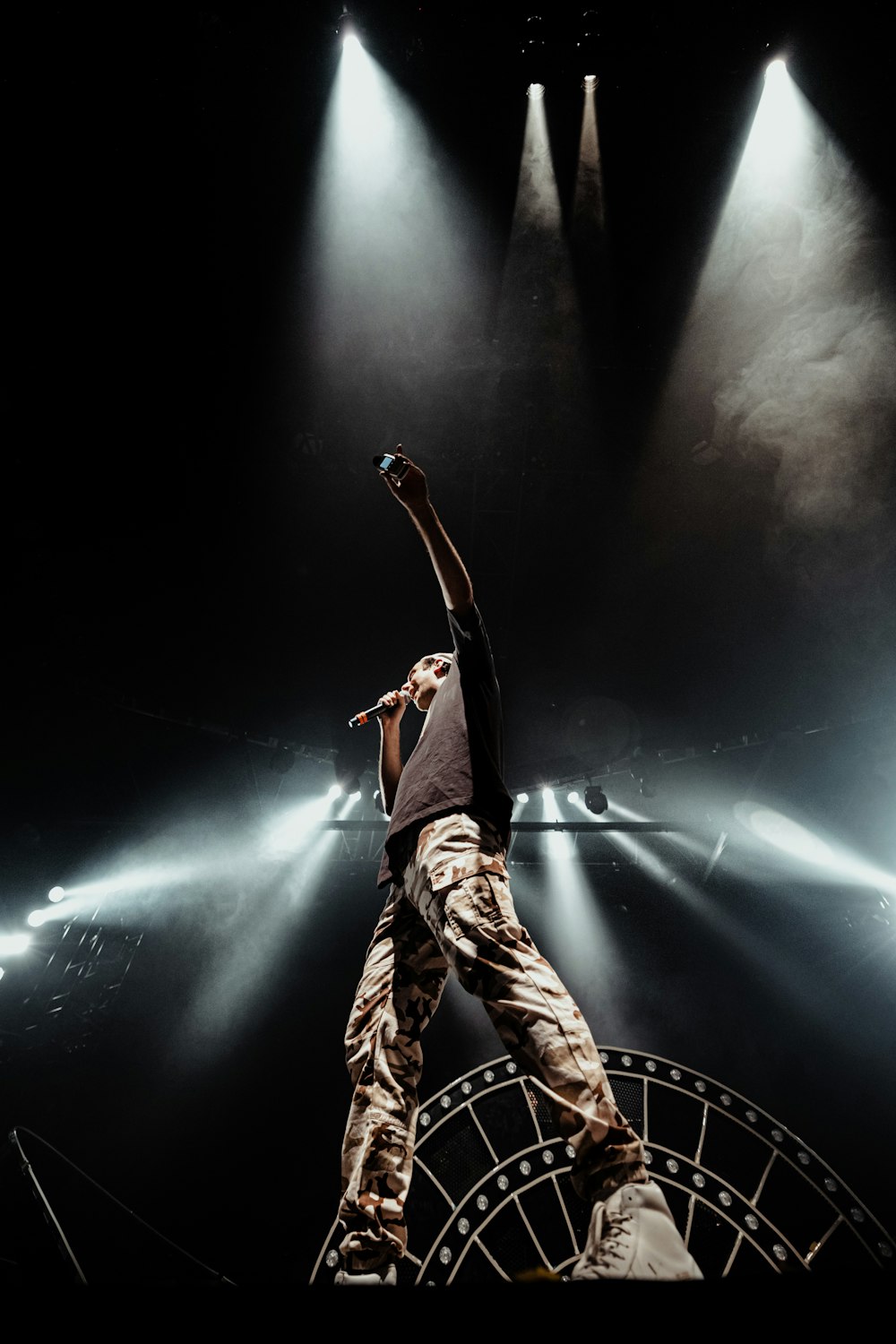 a man standing on a stage with his arms in the air