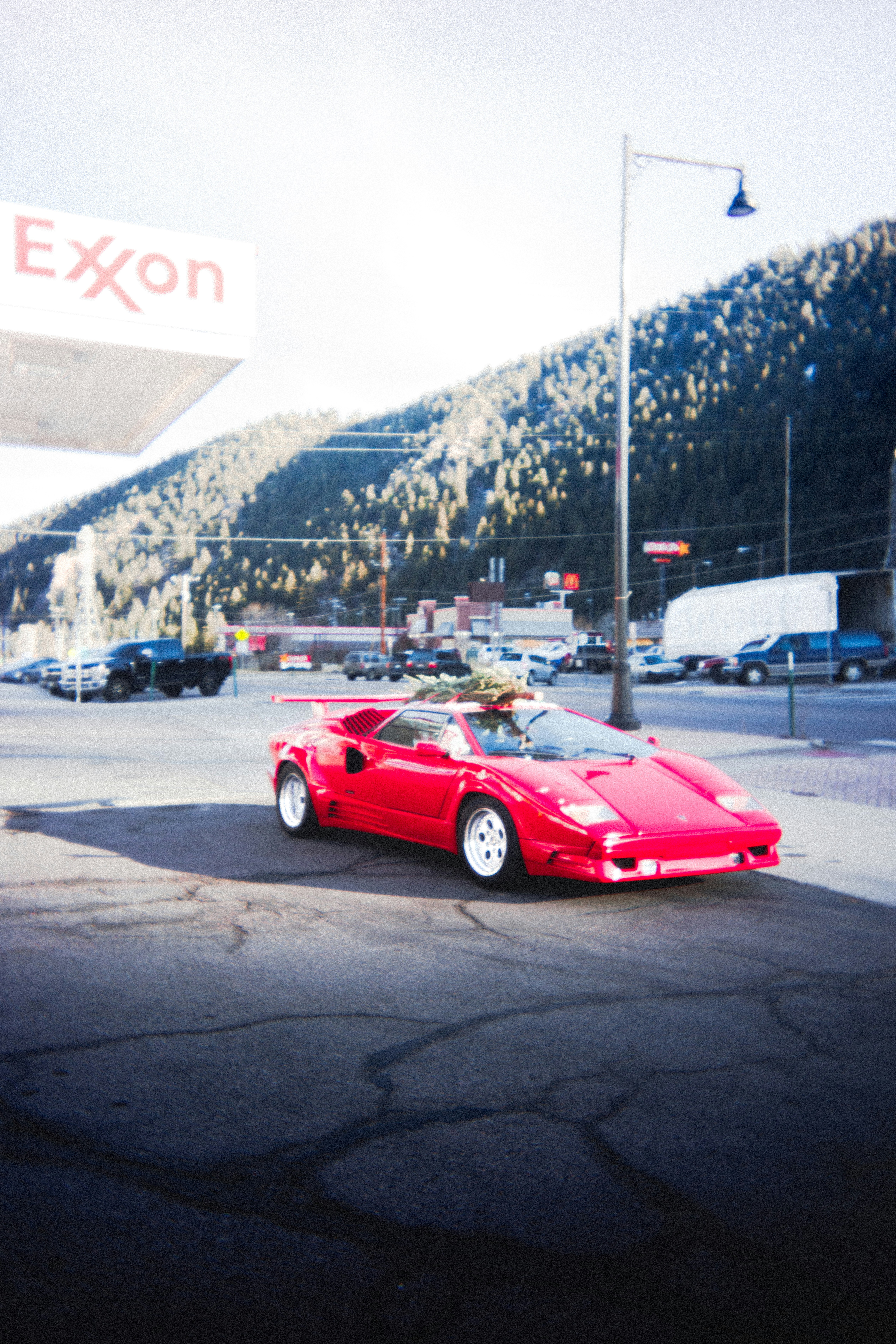 a red sports car parked in front of a gas station
