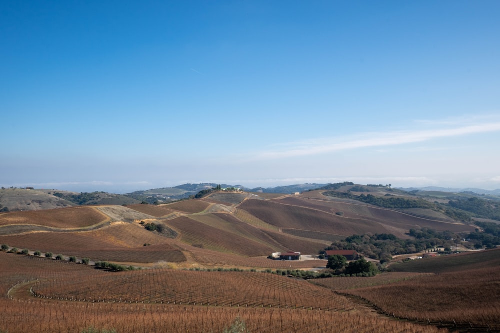 a scenic view of a farm and rolling hills