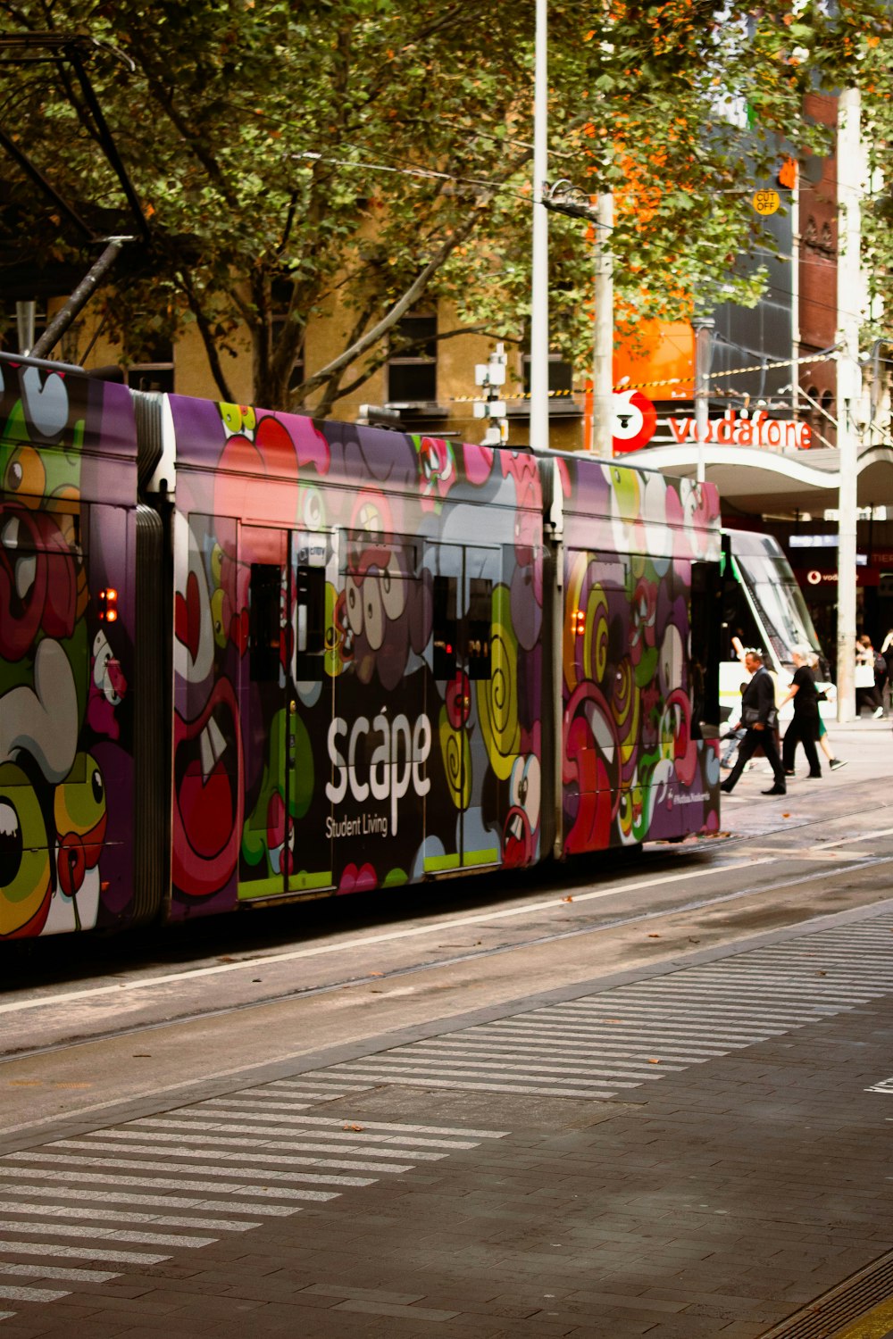 a colorful train is traveling down the street