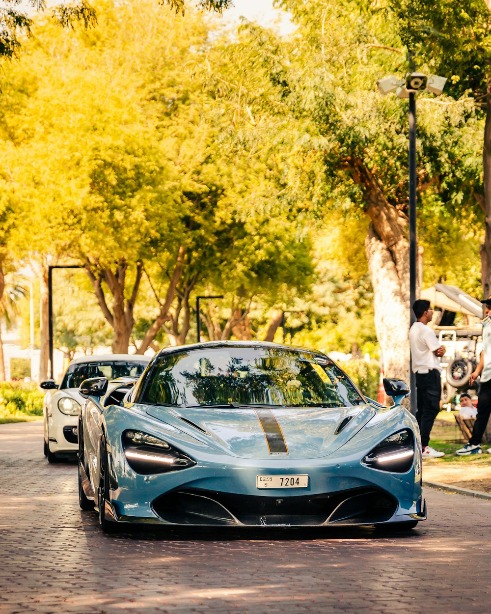 a blue sports car parked on the side of a road