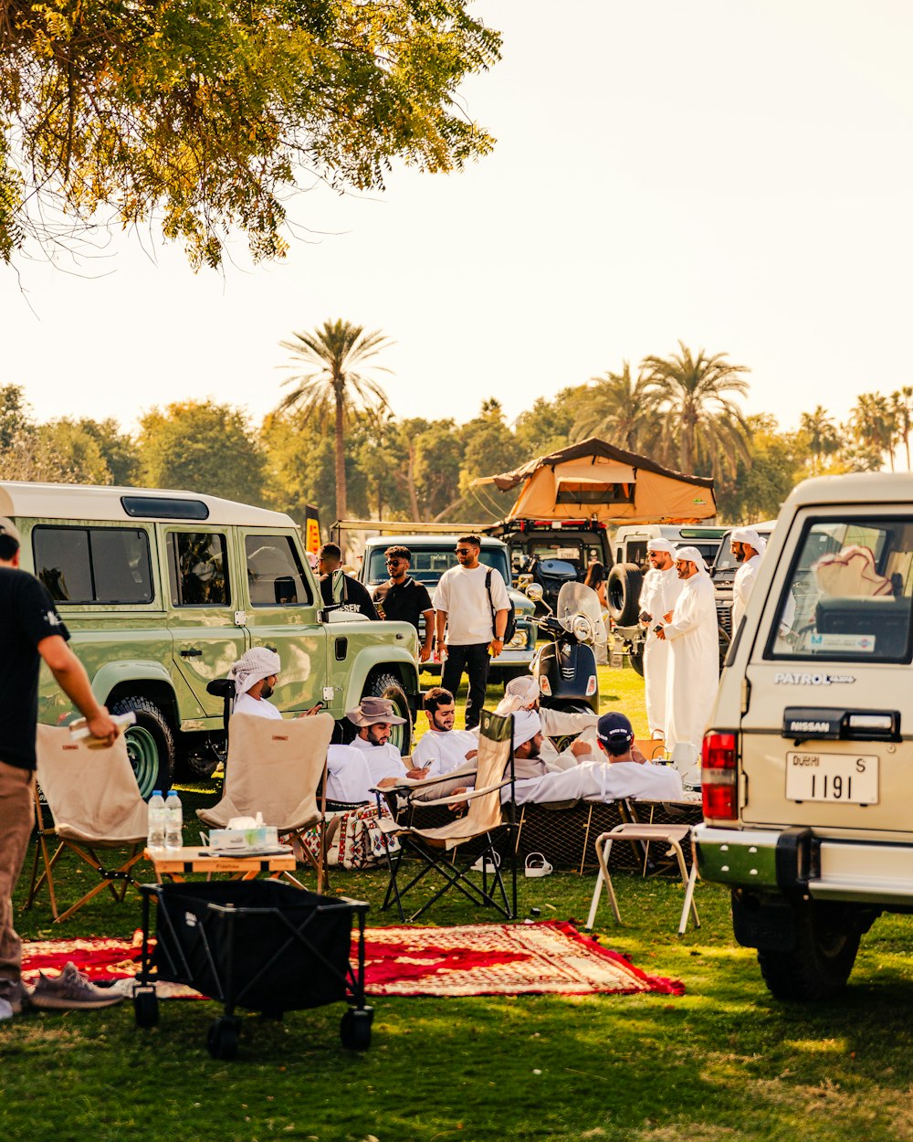 a group of people sitting in lawn chairs next to a truck