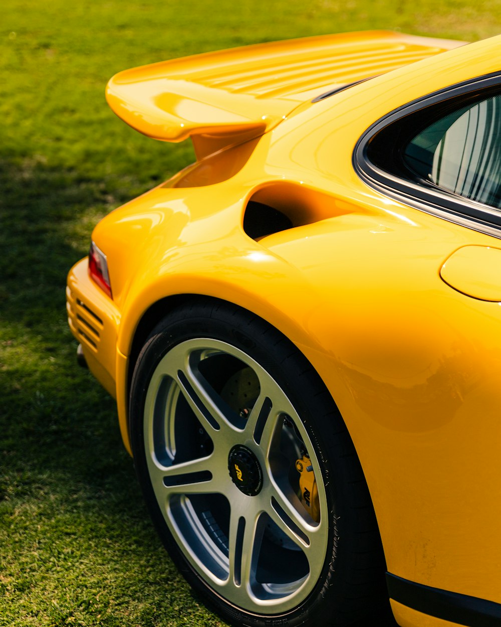 um carro esportivo amarelo estacionado em um campo gramado
